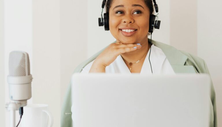 Woman wearing headphones recording audio on the computer